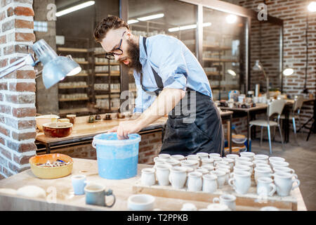 Belle peinture à l'argile travailleur, produits de plongée dans l'océan bleu avec la peinture à l'atelier de poterie Banque D'Images