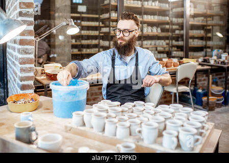 Belle peinture à l'argile travailleur, produits de plongée dans l'océan bleu avec la peinture à l'atelier de poterie Banque D'Images