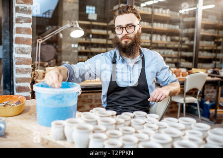 Belle peinture à l'argile travailleur, produits de plongée dans l'océan bleu avec la peinture à l'atelier de poterie Banque D'Images