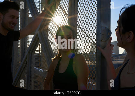 Amis parler à côté de mur clôturé dans les stades sportifs Banque D'Images