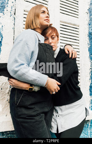 Women hugging, volets en arrière-plan Banque D'Images