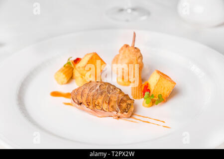 Les cailles dans le jus d'herbes et de la variation de maïs - cailles aux champignons royal flocons, jus d'herbes, polenta cubes, vitrage mini maïs et maïs crème, servi dans un wh Banque D'Images