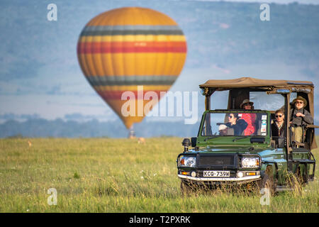 Un ballon à air chaud des terres dans l'arrière-plan comme par les touristes dans un visualisateur dans Masai Mara National Reserve, Kenya Banque D'Images