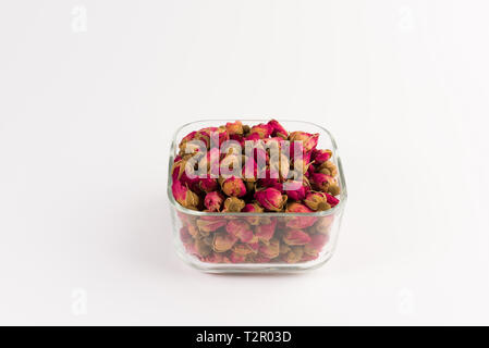 Plateau boutons de rose dans un bol d'alcool de verre isolé sur fond blanc Banque D'Images