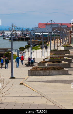 Les gens qui marchent le long de la front de Steveston sur un matin de printemps ensoleillé Banque D'Images