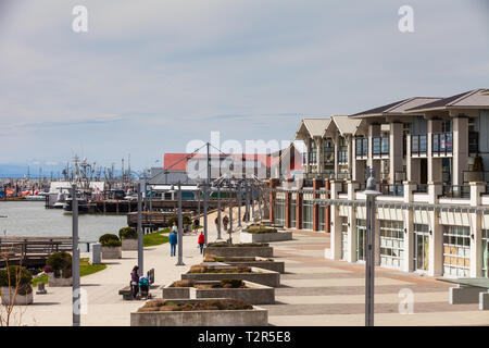 Les gens qui marchent le long de la front de Steveston sur un matin de printemps ensoleillé Banque D'Images