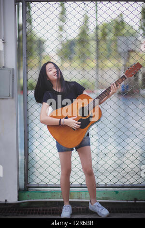 Asian teenager playing guitare espagnole avec bonheur l'émotion Banque D'Images