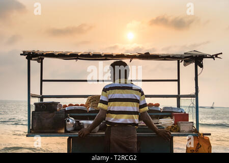 COLOMBO, SRI LANKA - Février 19, 2019 : un homme du Sri Lanka vendeur de fruits de mer vente fried debout à côté de son échoppe magasin au Galle Face beach food Banque D'Images