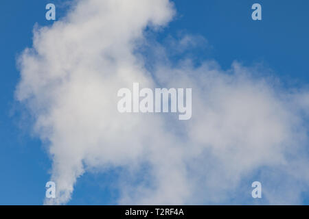 White fumée nocive provenant de la croix rouge et blanc avec des tuyaux d'antennes de communication mobile dans une usine dans le centre-ville dans le contexte de Banque D'Images