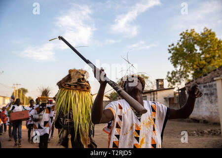 JANJANBUREH, la Gambie (18/01/2019) - Le maître de l'Egun Odeh transes momentanément tout en menant la mascarade à travers les rues de Janjanbureh. Le Festival Janjanbureh Kankurang fait partie d'efforts conjoints de l'UE au Fonds d'affectation spéciale d'urgence pour l'Afrique et le projet d'autonomisation des jeunes Gambiens pour stimuler le tourisme à Janjanbureh. En préservant et en célébrant le patrimoine culturel de l'Kankurang, c'est la création de nouvelles possibilités économiques pour les jeunes Gambiens sous la forme d'une augmentation du tourisme. Banque D'Images