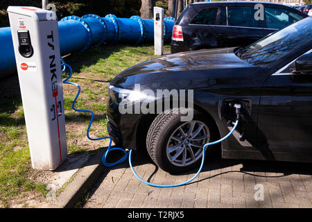 Une BMW 530e à une station de charge de la Mobilstation sur le Charles-de-Gaulle dans le quartier de Deutz, Cologne, Allemagne. Avec une connexion directe Banque D'Images