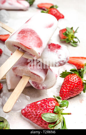 Des sucettes glacées avec du yogourt ou de la crème glacée aux fraises Banque D'Images