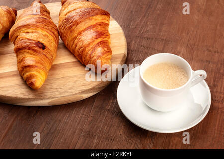 Une photo gros plan d'une tasse de café avec les croissants sur un fond de bois rustique foncé with copy space Banque D'Images