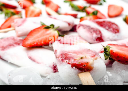 Sucettes glacées aux fraises juteuses naturel avec du yogourt ou de la crème glacée aux fruits rouges. Banque D'Images