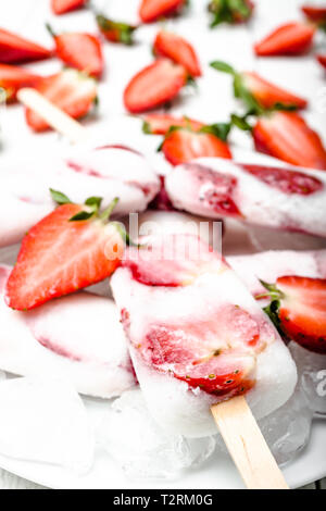 Des fraises fraîches les sucettes glacées au yogourt et fraises. La crème glacée à des bâtonnets. Banque D'Images