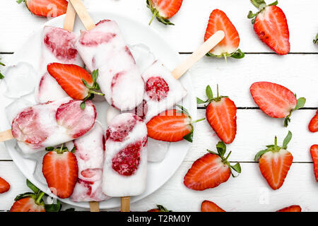 Des fraises fraîches les sucettes glacées au yogourt et fraises. Sucettes glacées, mise à plat, vue du dessus Banque D'Images