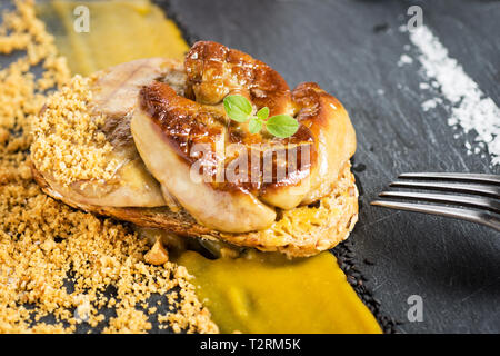 Foie Gras à la purée de mangue sur pierre sombre arrière-plan. Cuisine française plat Foie de Canard. Banque D'Images