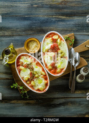 Boulettes de pommes de terre italienne gnocchi alla sorrentina de fromage mozzarella, cuit au four avec une sauce tomate et fines herbes. Servi avec du parmesan et des épices. Banque D'Images