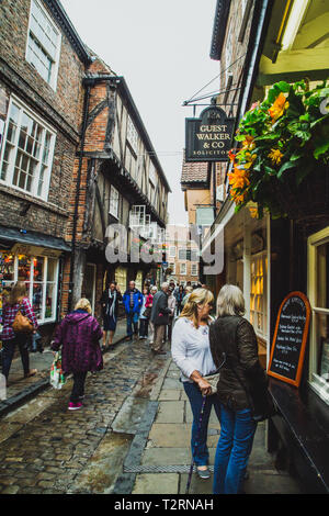 York, North Yorkshire. La pagaille dans une rue étroite avec les gens de New York dans la rue avec le flou. Banque D'Images