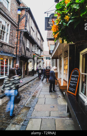 York, North Yorkshire. La pagaille dans une rue étroite avec les gens de New York dans la rue avec le flou. Banque D'Images