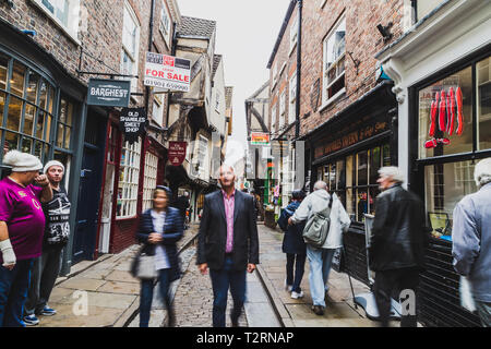 York, North Yorkshire. La pagaille dans une rue étroite avec les gens de New York dans la rue avec le flou. Banque D'Images