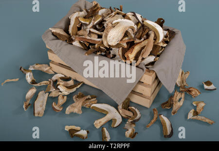 Beaucoup de tranches de champignons bruns secs Boletus edulis. Tranches de champignons séchés dans une petite caisse en bois Banque D'Images