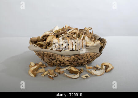 Beaucoup de tranches de champignons bruns secs Boletus edulis. Tranches de champignons séchés dans un panier de paille Banque D'Images