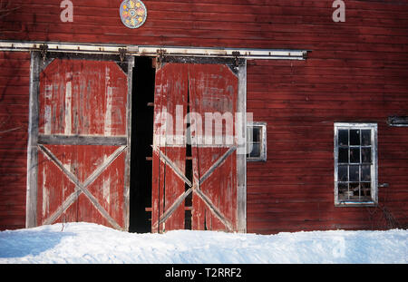 S'est évanoui coulissantes en bois portes de grange rouge sur une ferme du Vermont dans la neige Banque D'Images