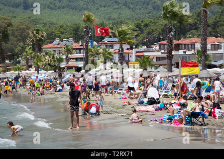 Les touristes et les habitants profitant du soleil sur la plage publique, Akyaka, province de Mugla, Turquie. Banque D'Images