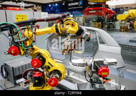 Hanovre, Basse-Saxe, Allemagne - Foire de Hanovre, des robots industriels welding et le transport de véhicules sur le stand Fanuc. Hanovre, Basse-Saxe, Deuts Banque D'Images