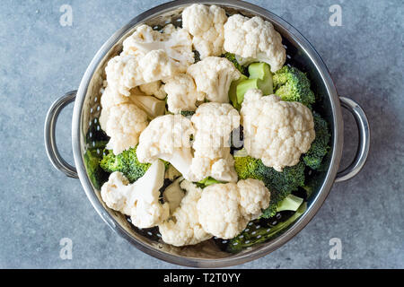 Chou-fleur et brocoli cru organique dans une passoire métallique. L'alimentation biologique. Banque D'Images