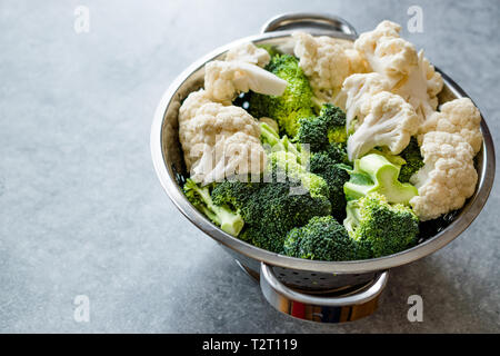 Chou-fleur et brocoli cru organique dans une passoire métallique. L'alimentation biologique. Banque D'Images