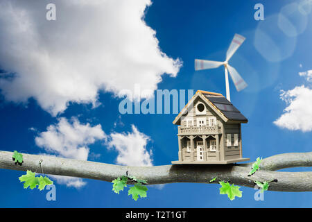 Fort d'oiseaux sur une branche alimenté par un panneau solaire et éolienne Banque D'Images