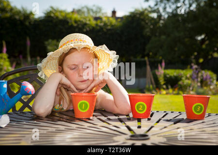 Ados pré caucasian girl looking at les pots de fleurs dans un jardin Banque D'Images