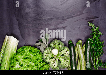 Variété de légumes verts et d'herbes. Manger des aliments propre concept. Tableau noir sur fond avec copie espace. Banque D'Images