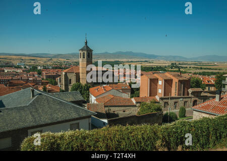 Clocher de l'église de briques au milieu des toits et la campagne paysage à Avila. Avec un imposant mur autour de la ville gothique en Espagne. Banque D'Images