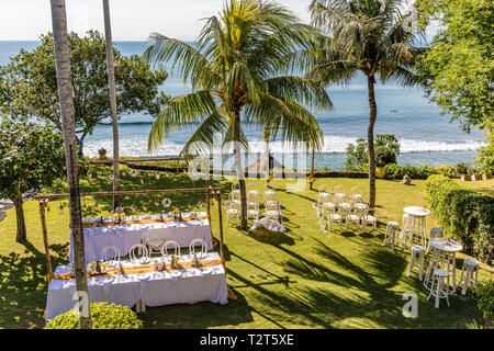 Pour une cérémonie de passage de mariage décoré de fleurs tropicales, et des chaises blanches sur le bord de la falaise de l'océan. Banque D'Images