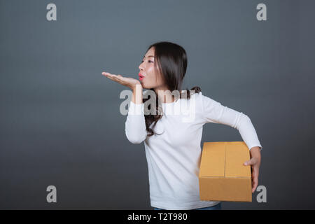 Femme tenant un brown post box fait des gestes avec la langue des signes. Banque D'Images