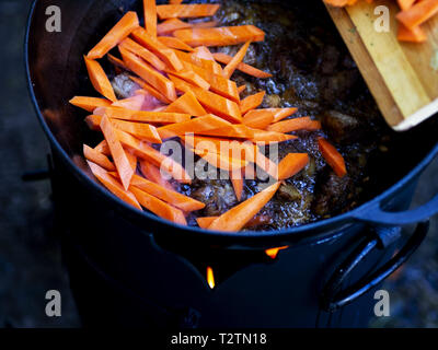 31 mars 2019 - Kiev, Ukraine - Carottes vu ajoutée à l'agneau..Pilaf est fait à partir d'agneau ou de boeuf, le riz, les carottes et les oignons avec les épices, c'est populaire non seulement parmi les peuples turcs. Habituellement, ce plat est préparé dans un pot en fonte spécial appelé chaudron et ils sont de différentes tailles, allant de 8 à 1000 litres. Nous avons utilisé le plus petit chaudron. (Crédit Image : © Igor Goiovniov/SOPA des images à l'aide de Zuma sur le fil) Banque D'Images