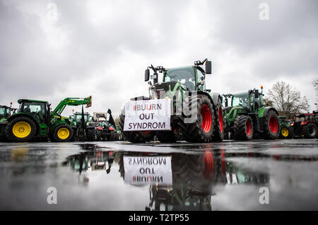 04 avril 2019, en Rhénanie du Nord-Westphalie, Münster : Sur un tracteur, une bannière avec l'inscription '# Buurn out Syndrom' se reflète dans une flaque d'eau. Des milliers d'agriculteurs manifester contre le durcissement de la loi d'engrais. Les organisateurs (Westfälisch Lippischer Landwirtschaftsverband Landwirtschaftsverband et Rheinischer) s'attendent à ce que 6000 participants, principalement de Rhénanie du Nord-Westphalie, mais aussi de la Basse-Saxe, Bavière, Hesse et de Mecklembourg-Poméranie-Occidentale. Photo : Guido Kirchner/dpa Banque D'Images