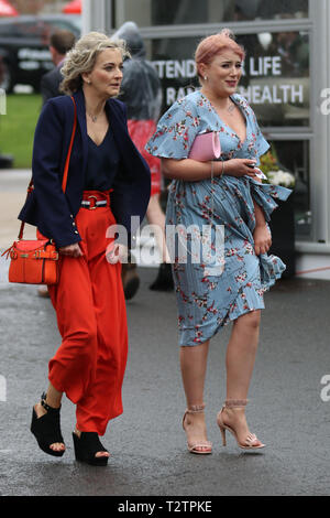 Deux pilotes glamour sur une route humide et venteuse à Aintree, Liverpool, Merseyside, Royaume-Uni. 4 avril 2019. Le célèbre événement de course hippique Grand National Randox Health accueille des fashionistas et des gens de style rue lors de ce défilé très spécial des plus belles mode chères femelles. Banque D'Images