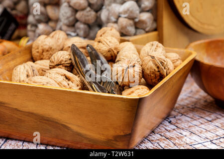 Ensemble les noix sont dans une plaque brune en bois sur une table en bois. Banque D'Images
