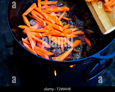 Les carottes vu ajoutée à l'agneau. Pilaf est fait à partir d'agneau ou de boeuf, le riz, les carottes et les oignons avec les épices, c'est populaire non seulement parmi les peuples turcs. Habituellement, ce plat est préparé dans un pot en fonte spécial appelé chaudron et ils sont de différentes tailles, allant de 8 à 1000 litres. Nous avons utilisé le plus petit chaudron. Banque D'Images