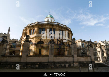 Une rangée de têtes sculptées en pierre montée sur le parapet et embarquement à l'Sheldonian Theatre dans Broad Street, Oxford, Angleterre Banque D'Images