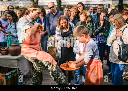 La Russie, Moscou ville - septembre 6, 2014 : l'enfant travaille sur un tour de potier. Un homme enseigne à un garçon pour faire un produit hors de l'argile. Banque D'Images