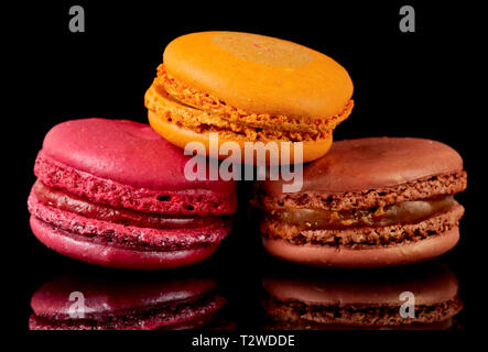 Trois macarons colorés isolé sur fond noir Banque D'Images