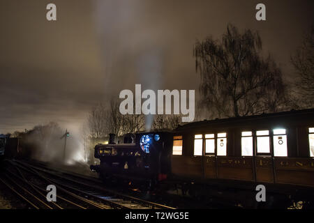 Ambiance moody vue nocturne passionnante, train à vapeur britannique vintage et train à train de fer vintage, laissant la gare dans le noir. Locomotives la nuit. Banque D'Images