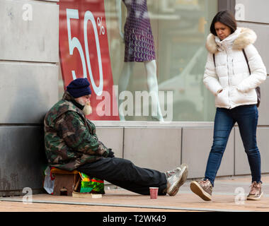 Sofia, Bulgarie - 22 janvier 2019 : Jeune femme sans-abri passe homme âgé qui prie pour l'argent en face d'un magasin de vêtements à Vitosha Boulevard dans les unités de Banque D'Images