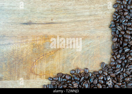 Des grains de café frais sur une texture en bois, la table peut être utilisé comme arrière-plan. Avec l'espace adjacent pour le texte Banque D'Images