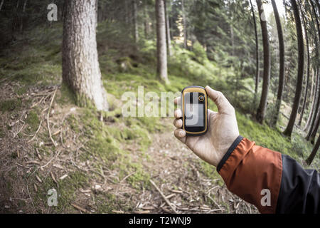 A l'aide du GPS Trekker parmi la forêt dans un jour nuageux Banque D'Images